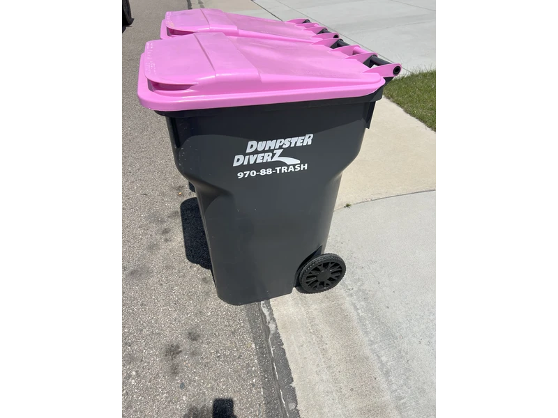 Dumpster Diverz employee in purple uniform checking residential trash cart in front of house